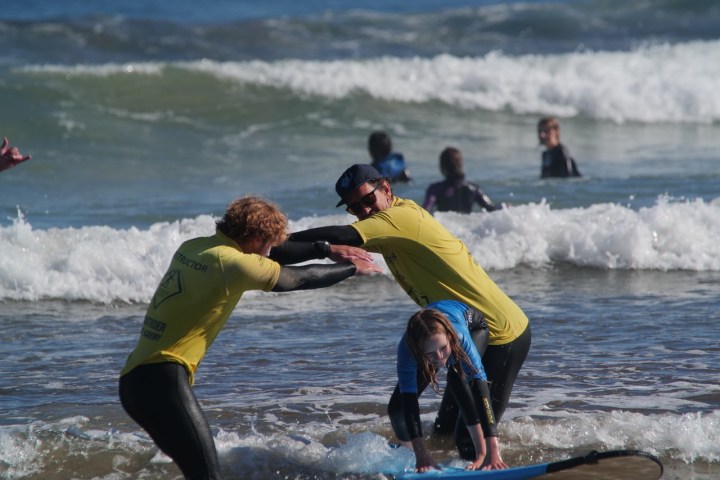 a man and a woman riding a wave on a surfboard in the water
