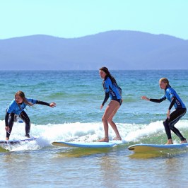a girl riding a wave on a surfboard in the water